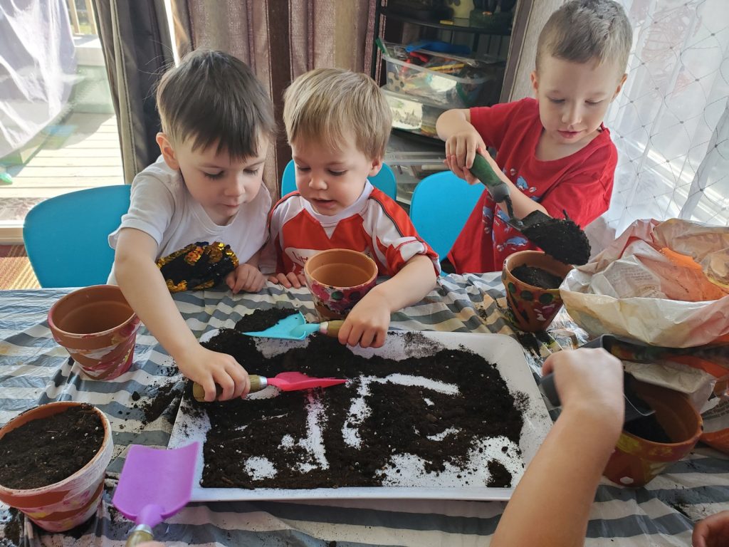 Children playing with dirt and planting.