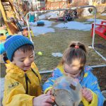 Boy and girl playing in the outdoor mud kitchen.