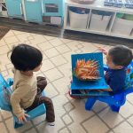 child reading a book to another child