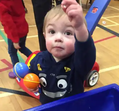 Toddler pointing in a gymnasium