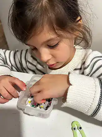 closeup of girl picking out plastic eyes