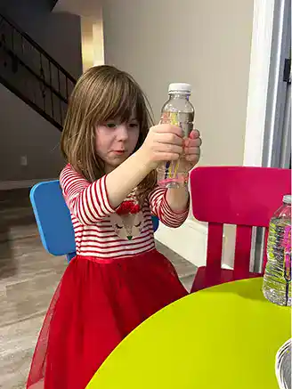 child squeezing bottle